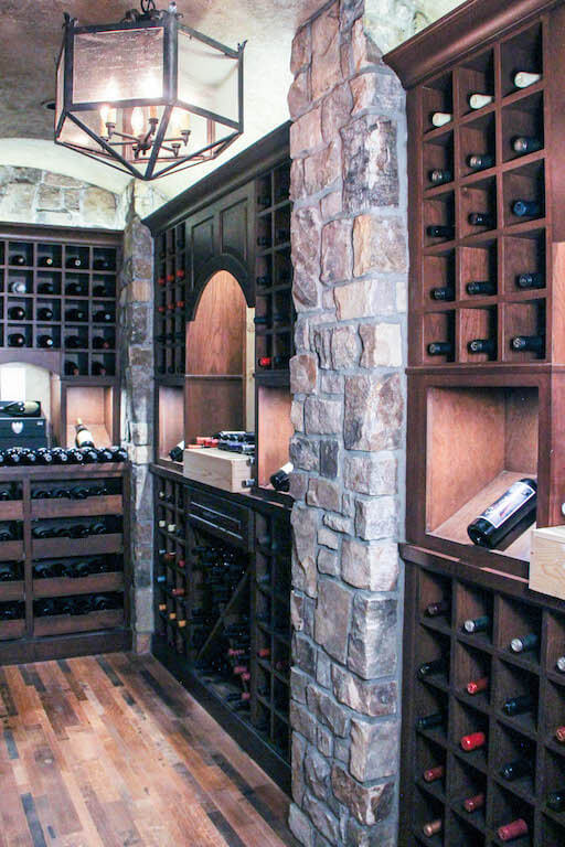 wine cellar with rock walls, dark wood storage areas