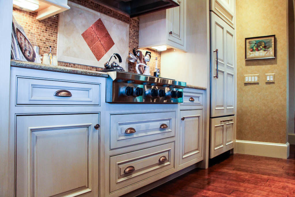 white kitchen cabinetry with copper-colored hardware